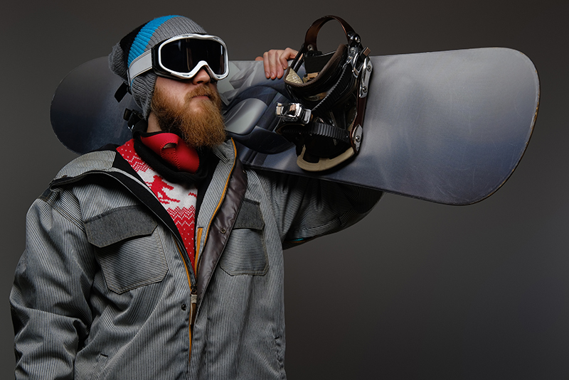 brutal man with red beard wearing full equipment holding snowboard his shoulder isolated dark background